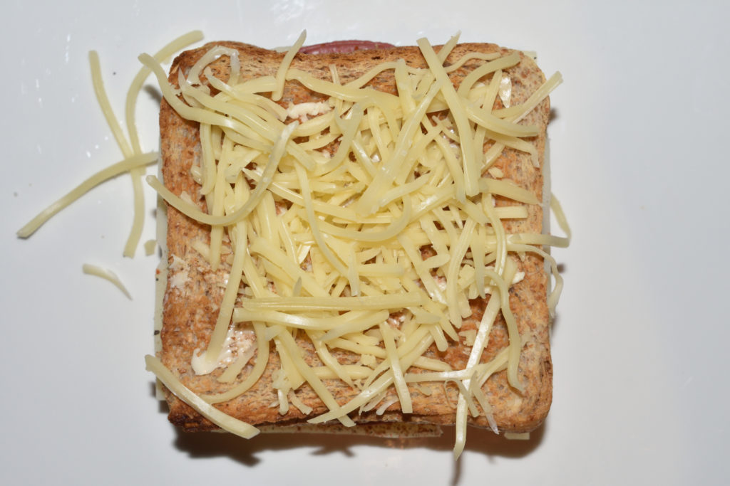 Croque Monsieur - Schicht für Schicht erklärt | Schritt 8: Bestreue den Toast mit geriebenem Emmentaler. Puh, geschafft ! Der Croque Monsieur ist beinahe fertig.