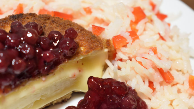 Ein echt französischer Klassiker feiert sein Comeback: In der Pfanne kross gebackener, panierter Camembert! Die herb-süßen Wildpreiselbeeren passen extrem gut zum milden Käse und dem Paprikareis als Beilage.