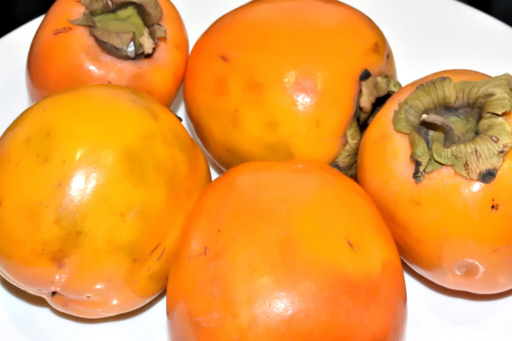Kakifrüchte - Reifegrad bestimmen | Je stärker die orangene Farbe, desto reifer und süßer die Frucht. Grüne Früchte sollten noch einige Tage bis zur Verarbeitung liegen bleiben. Ein paar braune Flecken sind übrigens ganz normal.